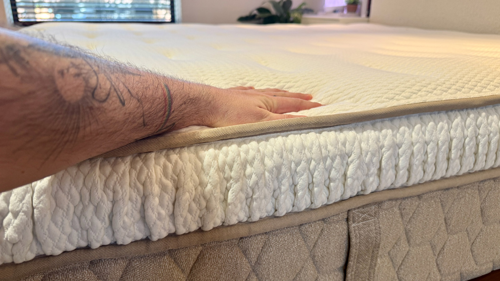 A hand pressing down into the Yinahla Premier Luxe mattress