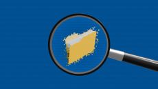 An illustration of a magnifying glass hovering over a noisy computer file folder, against a blue background, to represent memory forensics.
