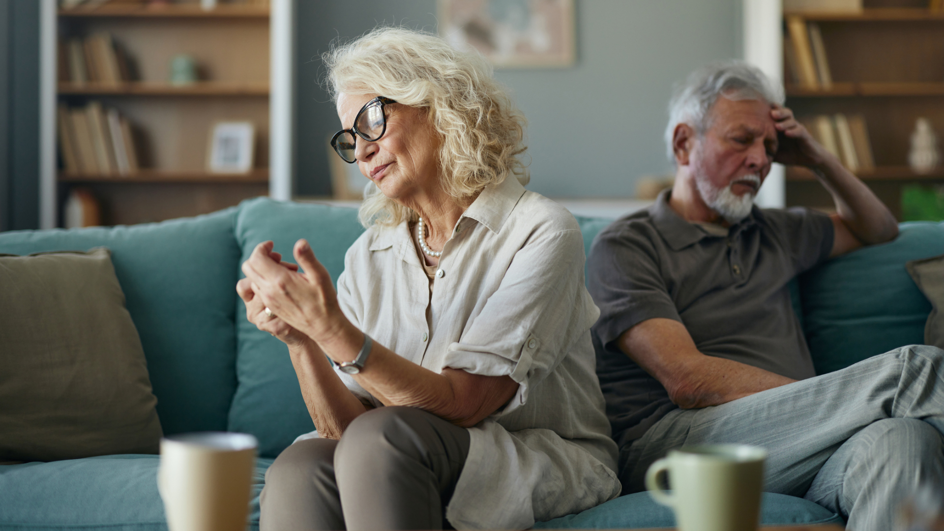 Careless mature woman ignoring her husband on sofa in the living room.