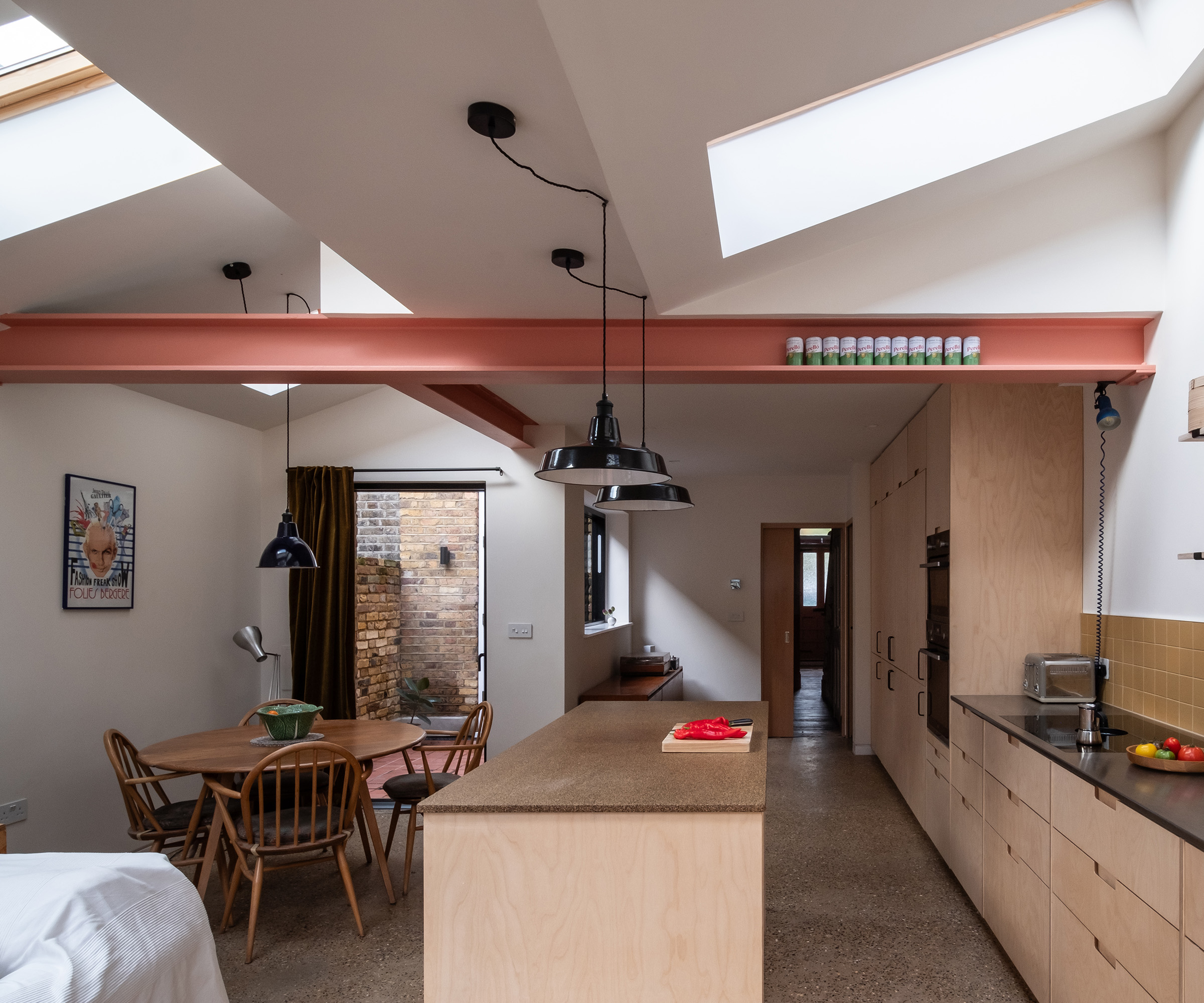 An open plan kitchen extension with exposed pink steel support beam. The roof is in a double pitch