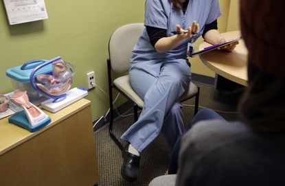 An unidentified Planned Parenthood medical practitioner speaks with a patient.