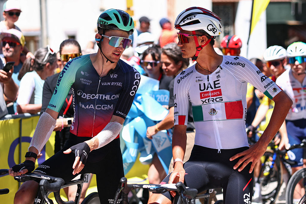 Paul Seixas (L) and Isaac Del Toro Romero speak at the start line before the 8th and final stage of the Tour Auvergne-Rhone-Alpes