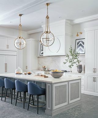 white kitchen with gray stained wood island and blue bar stools