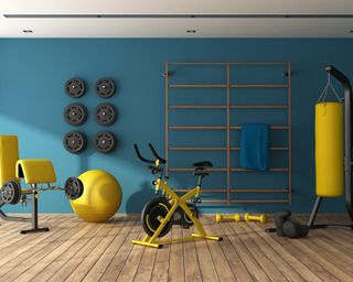 yellow gym equipment in a blue wall basement home gym - getty