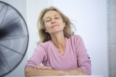 Woman sitting in front of fan 