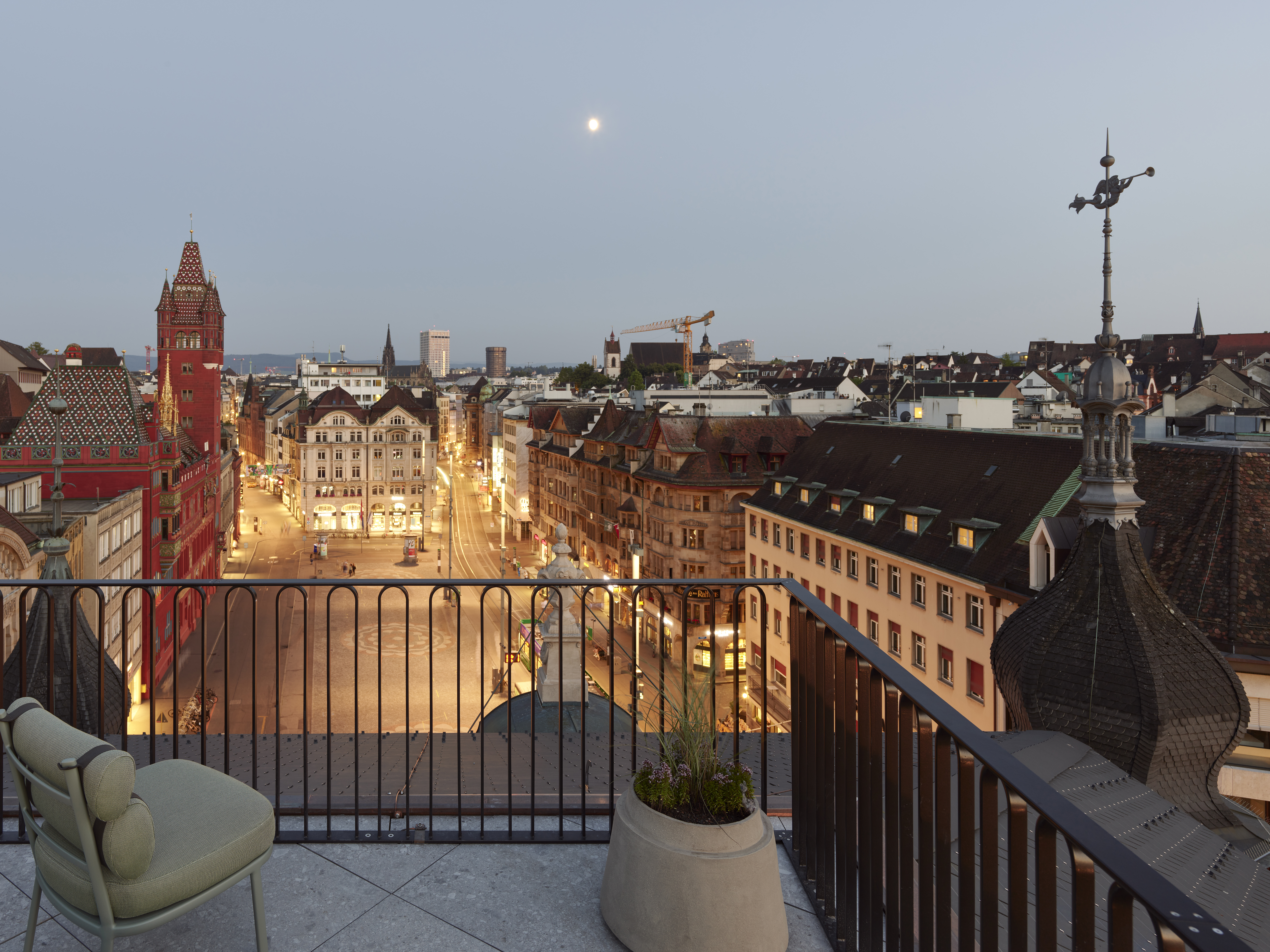 Photos of the exterior of Hotel M&amp;auml;rthof Basel, based in a beautiful square with historical landmarks at nighttime.