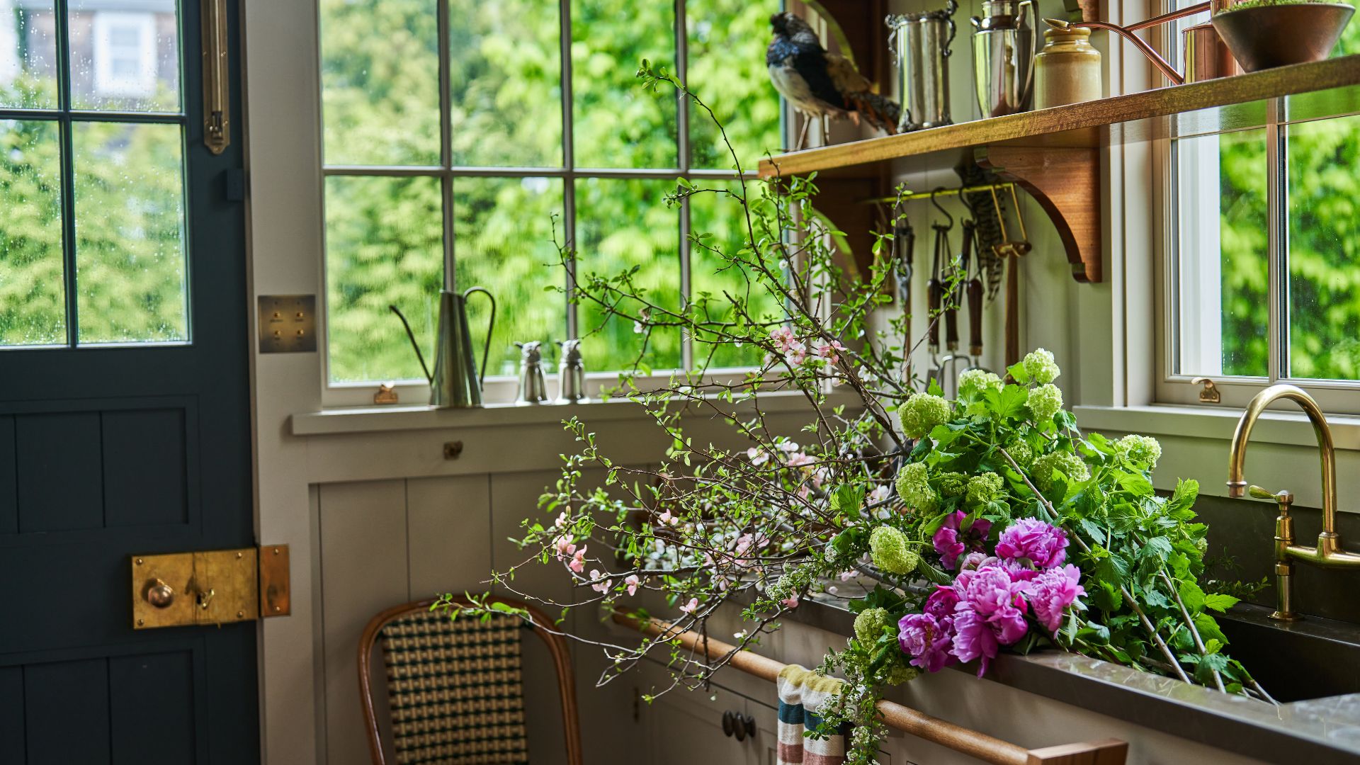 Sink full of flowers with open shelving above