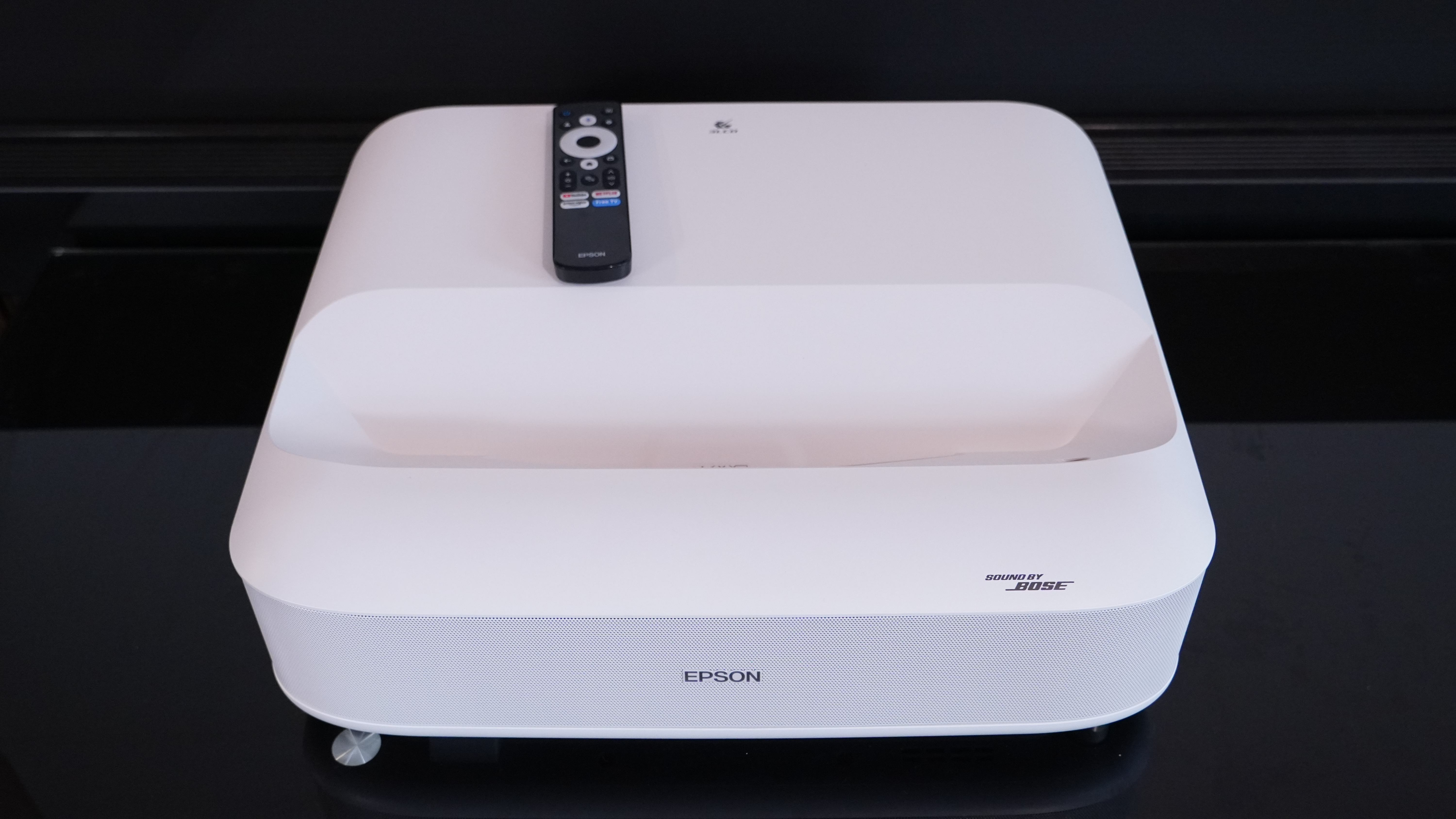 An overhead shot of the Epson LifeStudio Grand projector with its remote on the top
