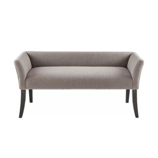 A gray upholstered bench with black wooden legs