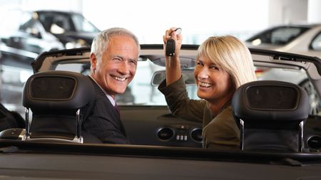 Overly cheerful people in a convertible car