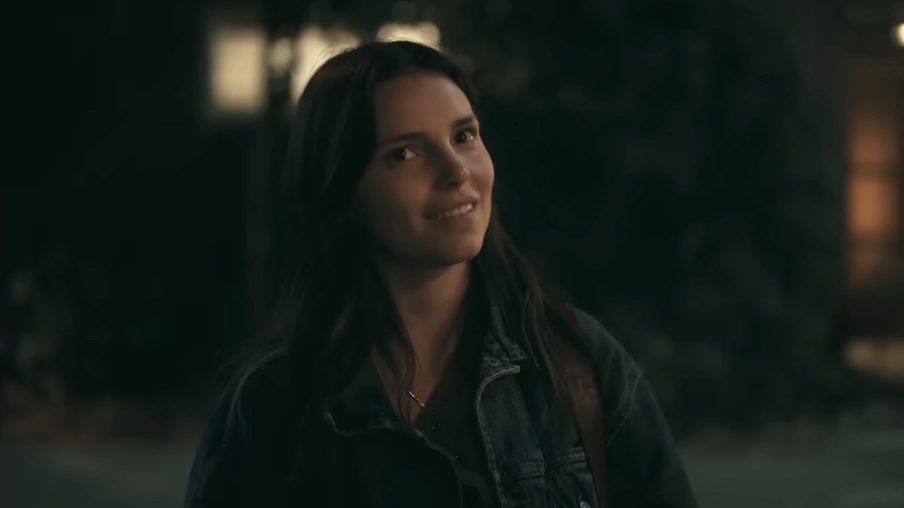 Nikki smiling outside in Obsession.