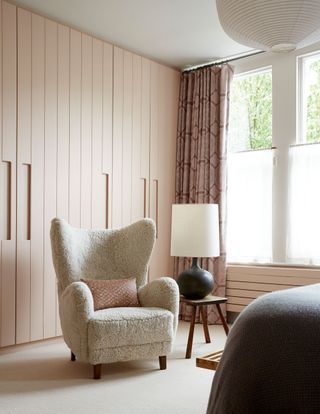 a boucle armchair in a pink bedroom