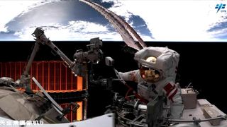 an astronaut in a white spacesuit works outside a space station with earth in the background