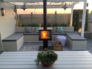 Four sided central outdoor fireplace in the middle of a modern patio space