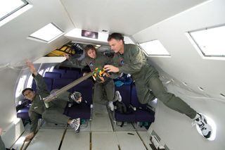 Authors Robert Ferl (front) and Anna-Lisa Paul (middle) conduct a plant experiment in the microgravity conditions of NASA’s parabolic flight aircraft.