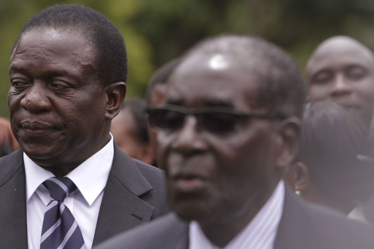 Emmerson Mnangagwa (left) Vice President of Zimbabwe stands behind Zimbabwean President Robert Mugabe in Dec. 2014.