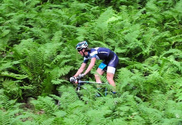 Sam Schultz (Subaru-Trek) riding fourth through the ferns.