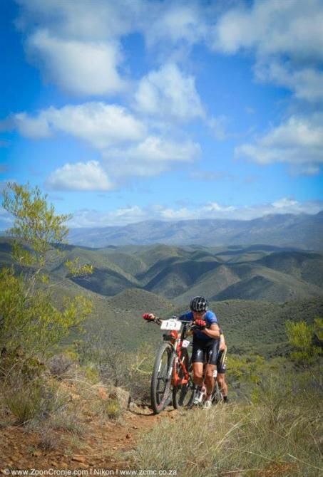 Defending champion, Gawie Combrink of Team Westvaal Bells Cycling, pushes his bike up a steep climb during Stage 2