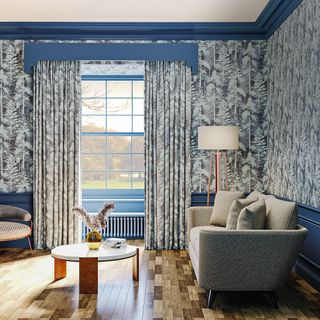 blue walled living room with patterned curtains and matching wallpaper