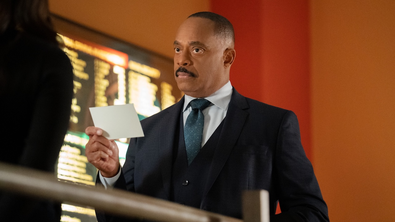 Rocky Carroll's Leon Vance holding a white card while standing in front of MTAC in NCIS