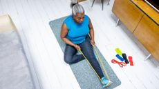 Woman exercises at home using a resistance band