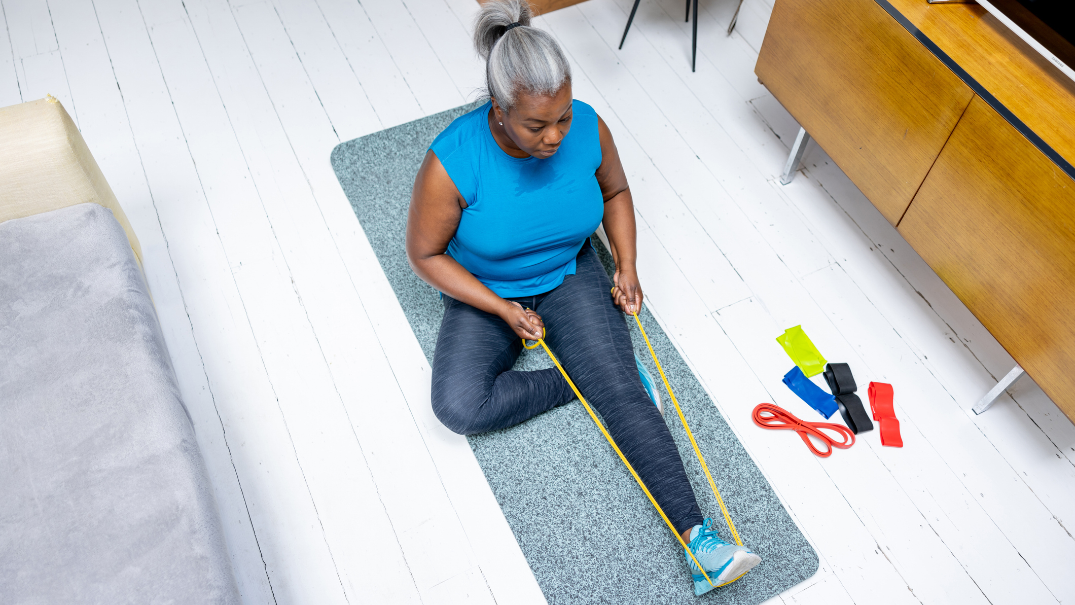 Woman exercises at home using a resistance band
