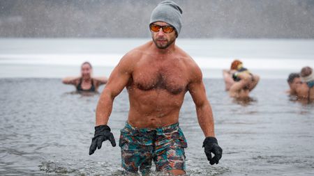 A man emerges from a swim in a lake