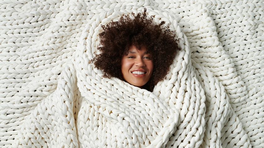 A woman wrapped in a Bearaby weighted blanket