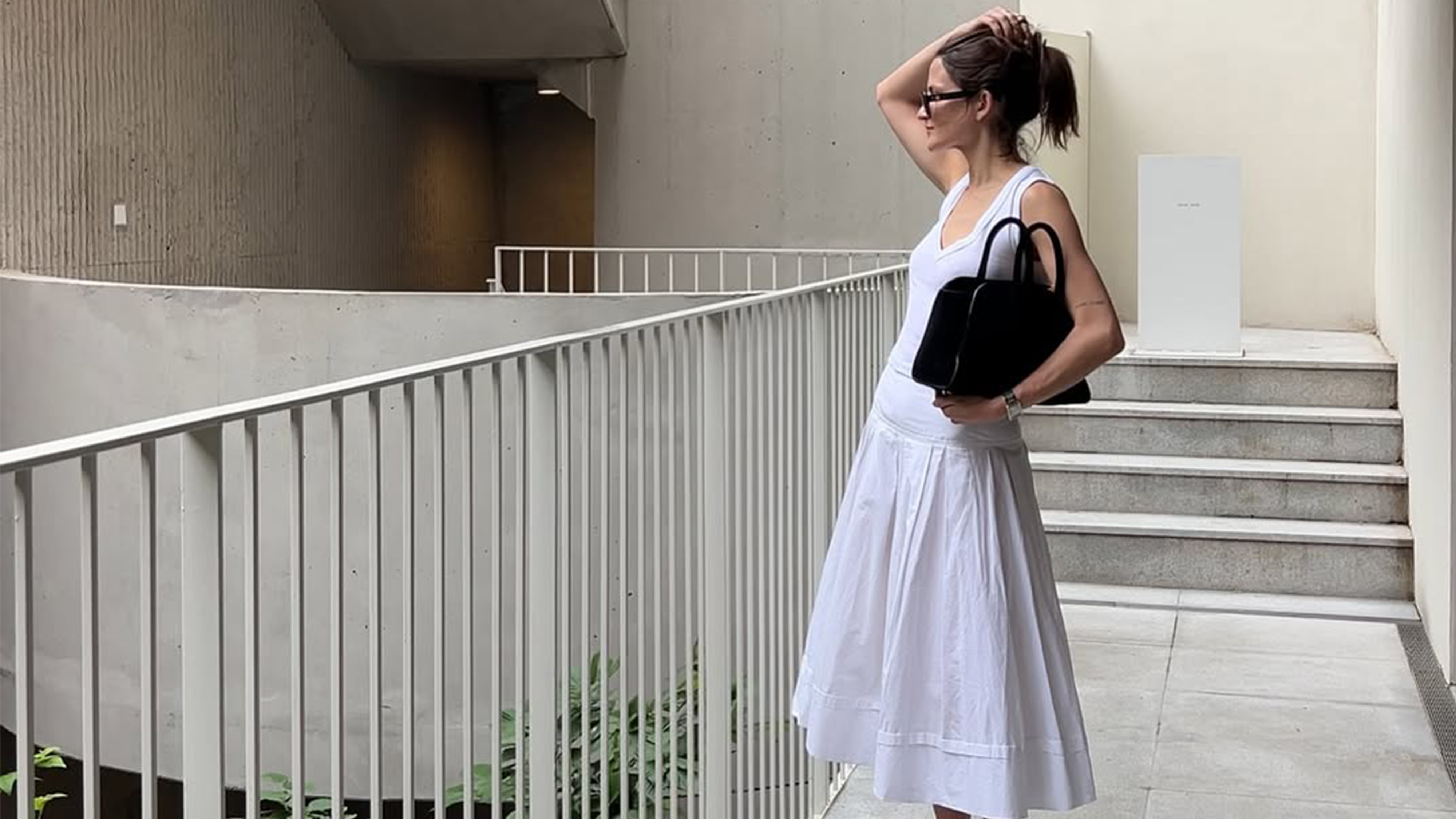 Eliza Huber wearing an all white outfit and black bag.