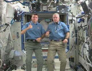 NASA astronauts Reid Wiseman (left) and Steven Swanson give a thumbs up to the Apollo 11 moon landing mission during a video marking the 45th anniversary of the epic lunar flight.