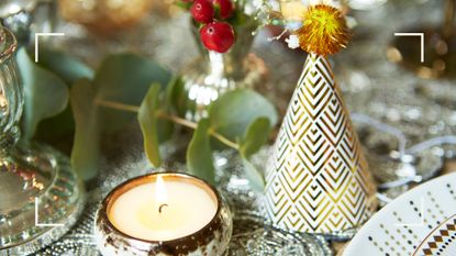 Christmas scene with a dining table dressed in silver and white with a party hat with a gold pom pom to show how to host a Christmas party in style