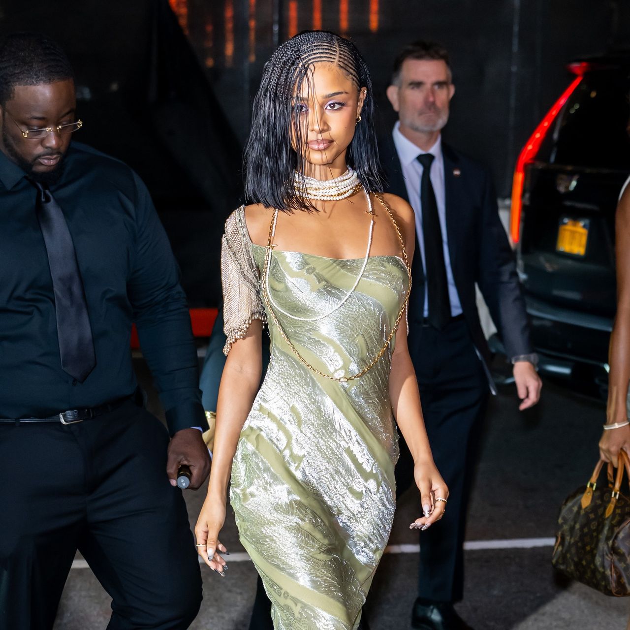a black woman with braids photographed by paparazzi