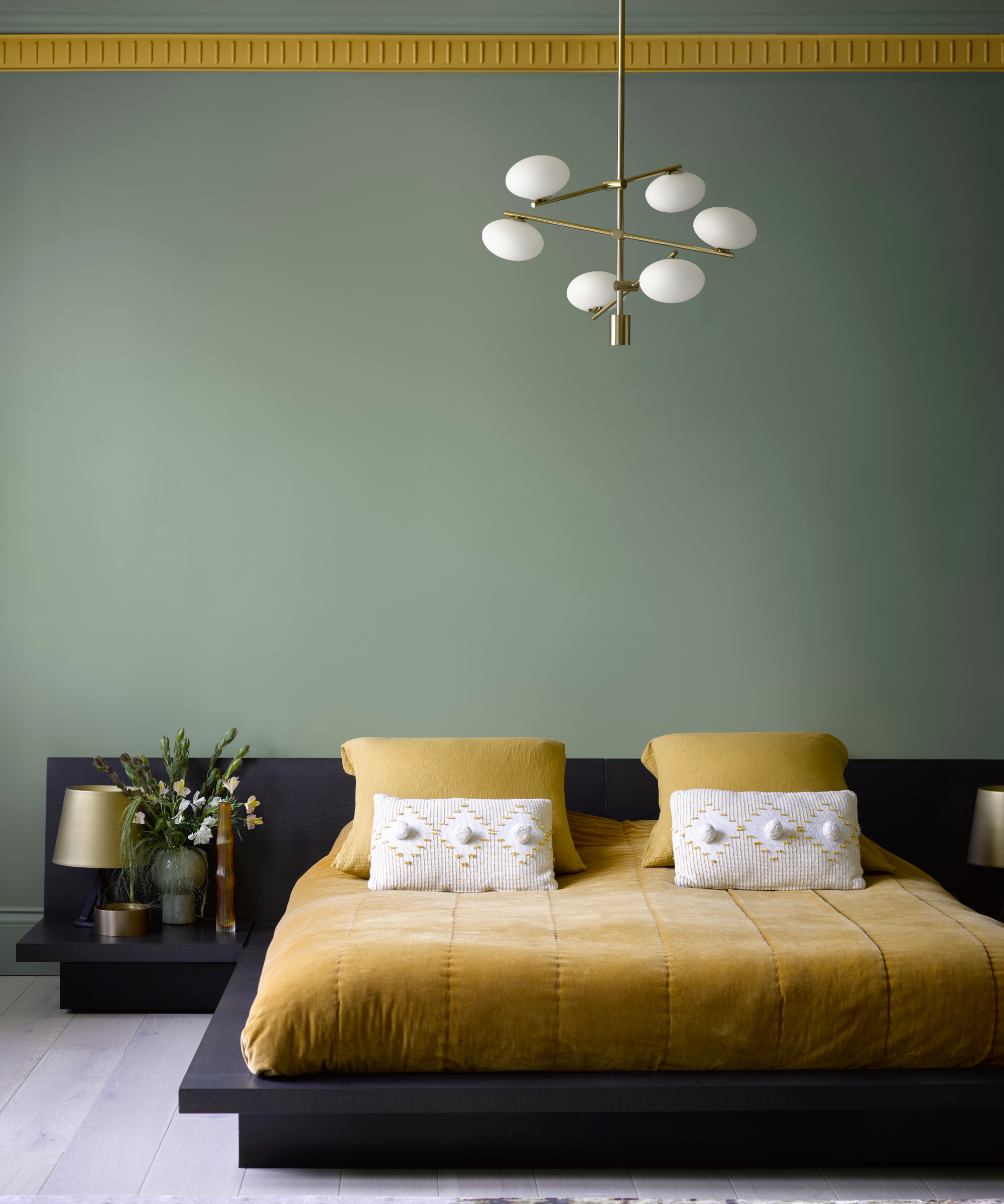 green painted walls with yellow trim, low navy platform bed with yellow bedding
