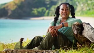 Cirie sits by a rock with a gorgeous view of Fiji in the background for a confessional on Survivor. 