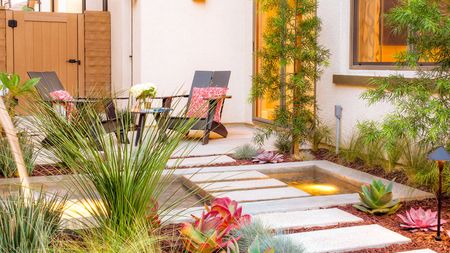 A contemporary side yard with pavers and a water feature