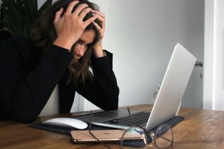 A person stressed in front of a computer.