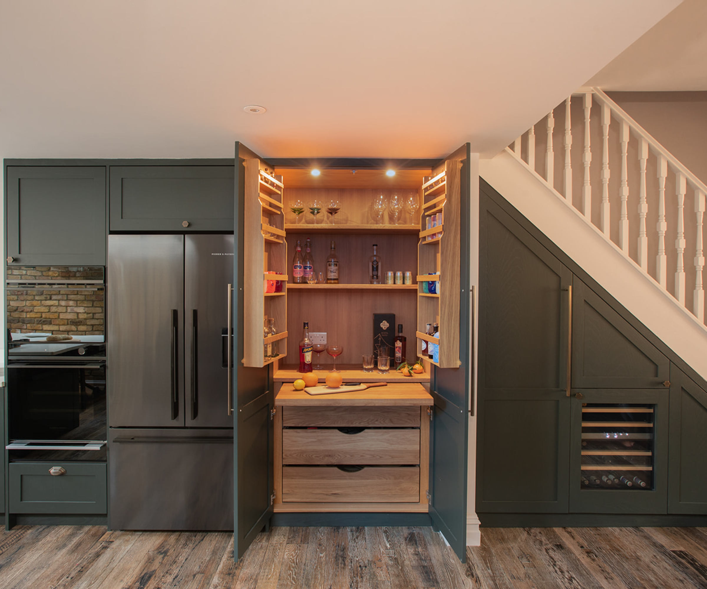 fitted pantry unit in kitchen that opens to reveal a home bar