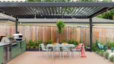 a large pergola above an outdoor kitchen and dining area