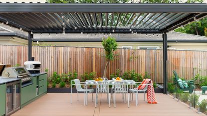 a large pergola above an outdoor kitchen and dining area