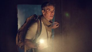 Cillian Murphy as Tommy Shelby holding up a flashlight with his left hand in Peaky Blinders: The Immortal Man.