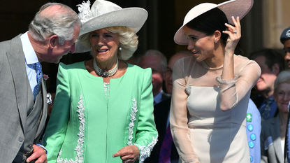 Britain's Prince Charles, Prince of Wales (L) and his wife Britain's Camilla, Duchess of Cornwall (C), talk with Britain's Meghan, Duchess of Sussex, as her husband Britain's Prince Harry, Duke of Sussex (unseen), speaks during the Prince of Wales's 70th Birthday Garden Party at Buckingham Palace in London on May 22, 2018. - The Prince of Wales and The Duchess of Cornwall hosted a Garden Party to celebrate the work of The Prince's Charities in the year of Prince Charles's 70th Birthday. 