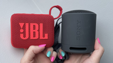 The JBL Go 4 and Sony XB100 held in the author's hands