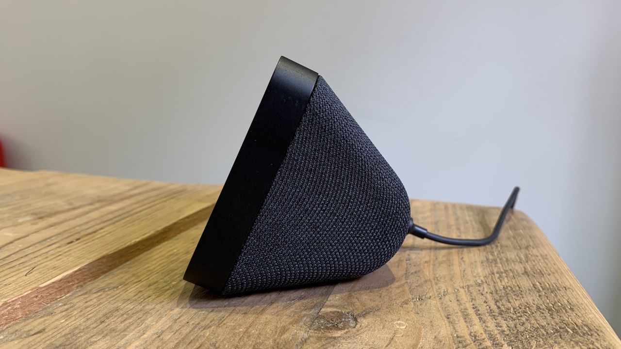 A side profile of a black Amazon Echo Show 5 smart speaker. It is generally triangular in shape with a power cable protruding from the back.