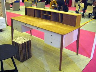 Wooden desk with drawers on display in a design event