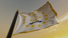 picture of Rhode Island state flag on pole against golden sky