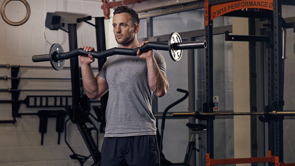 Man performs reverse curl using an EZ-bar