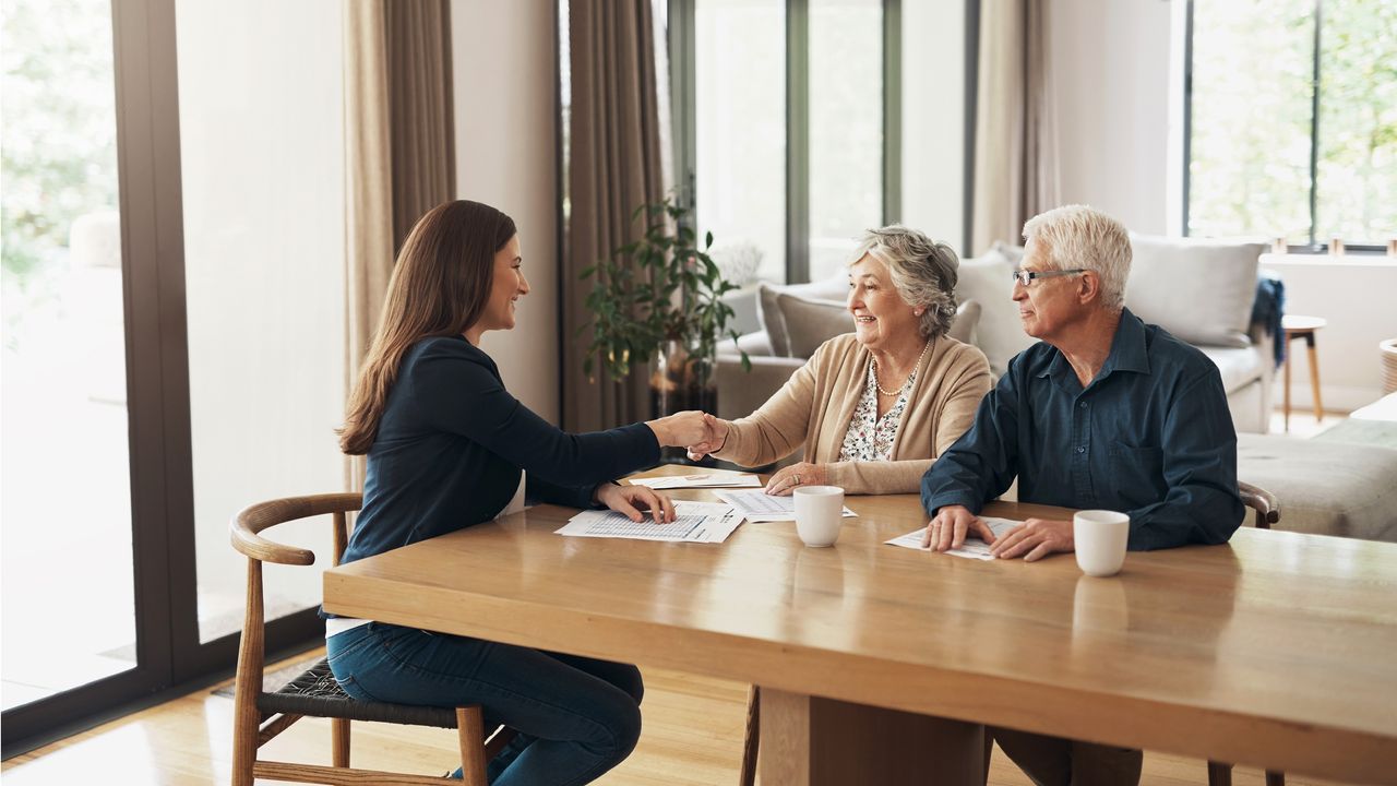 An older couple talk with an estate planning attorney in her office.