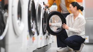 Woman looking at new washing machine in a store