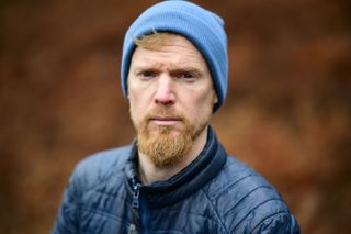 Viltrox AF 85mm F1.4 Pro lens sample gallery: man in a blue beanie, with blurry bronze-colored ferns in the background