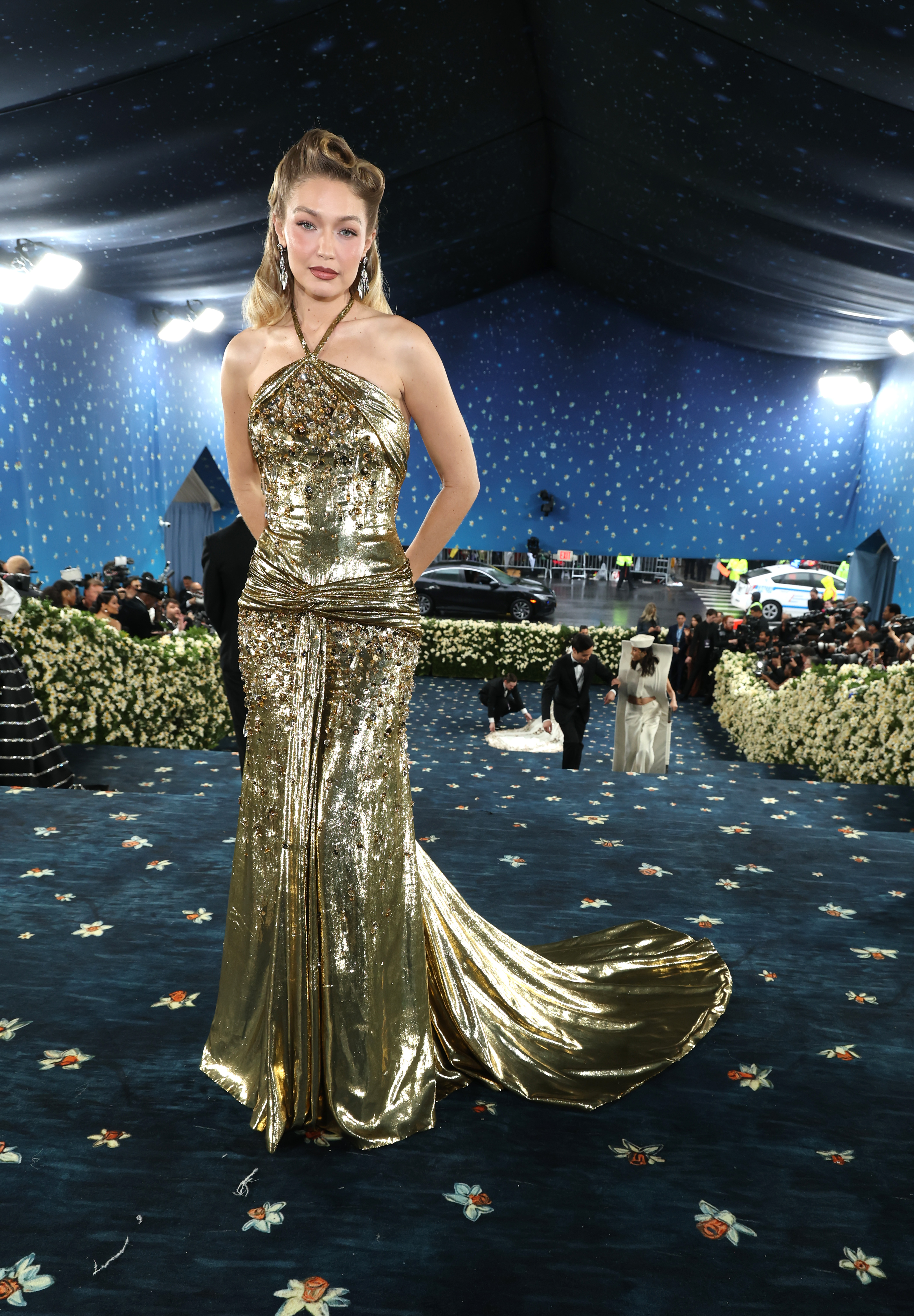 Gigi hadid wears a gold halter dress to the met gala.